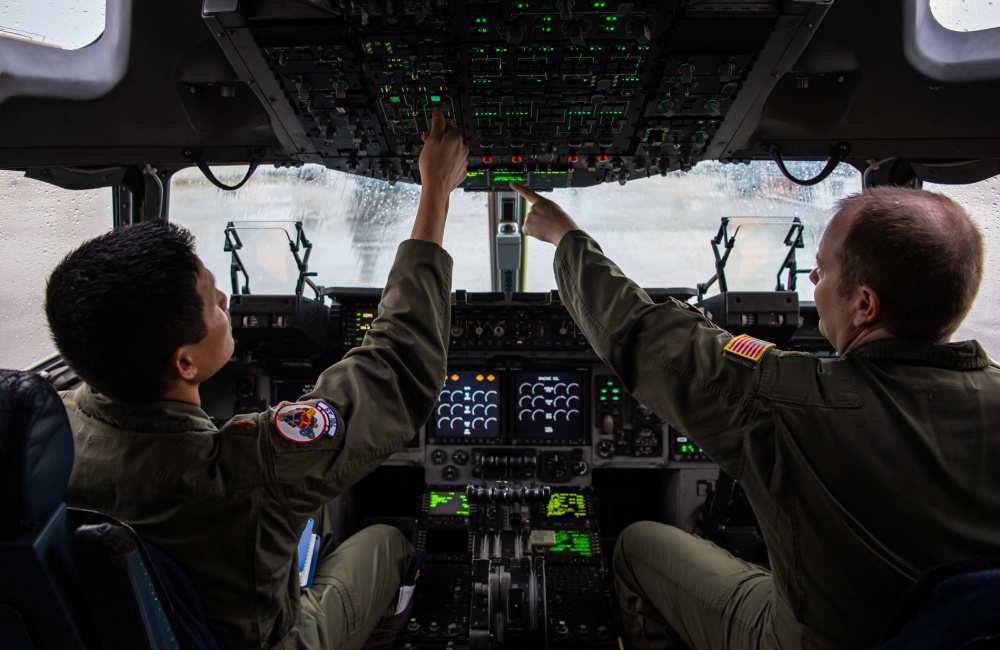 pilots adjusting gauges in cockpit 