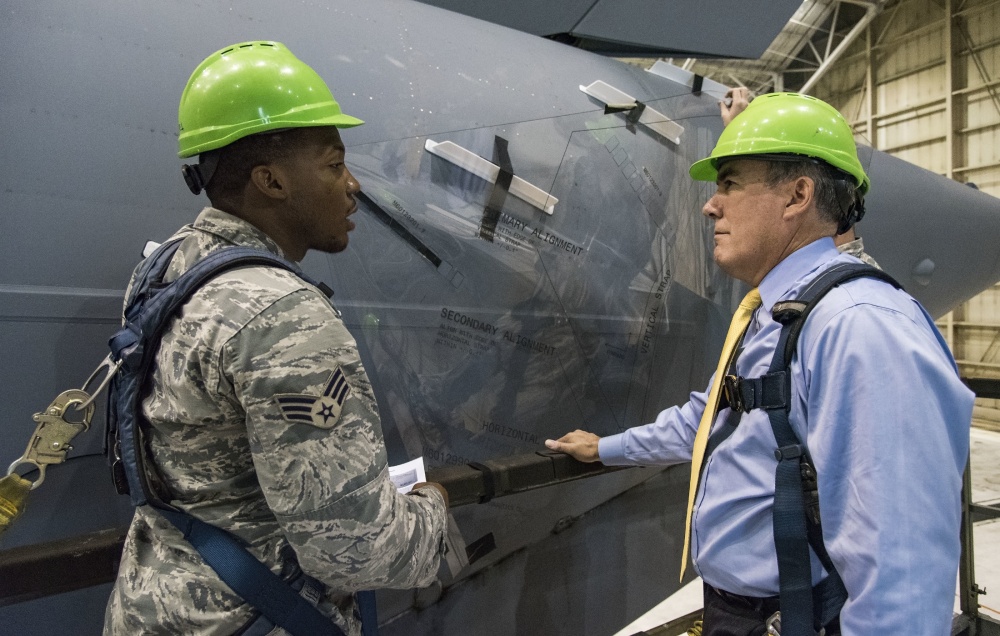 two men standing next to aerodynamic devices on aircraft 