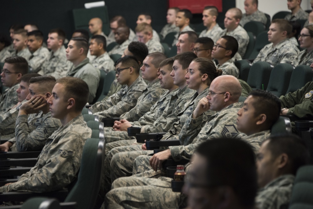 group of airmen in conference room listening to speaker 